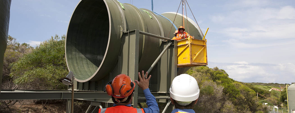 A large composite pipe section being installed